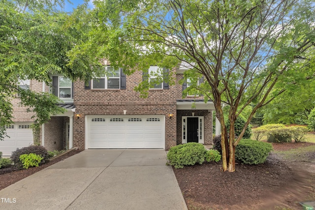 view of front of property featuring brick siding, a garage, and concrete driveway