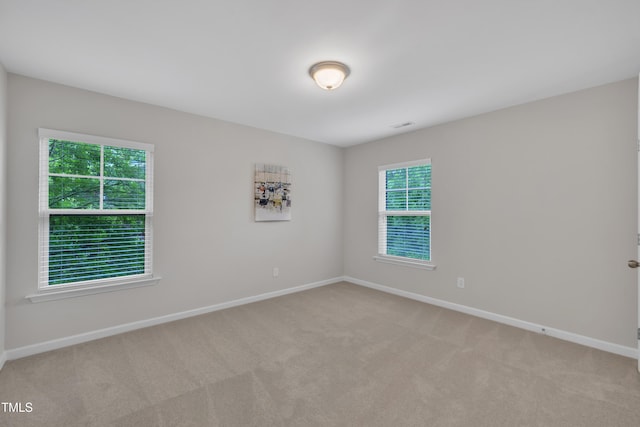 unfurnished room featuring plenty of natural light and baseboards