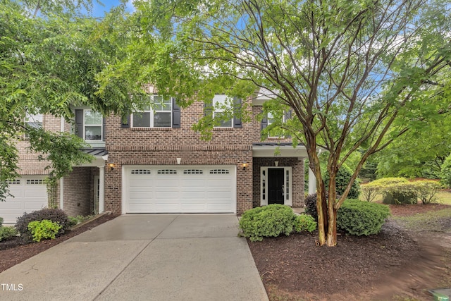 view of front of property featuring an attached garage, brick siding, and driveway