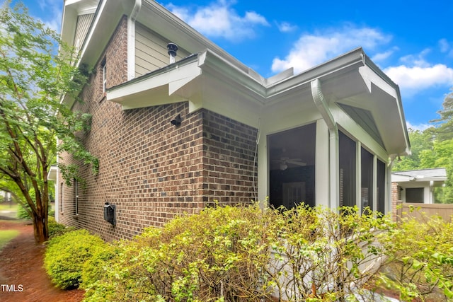 view of home's exterior with brick siding and a sunroom