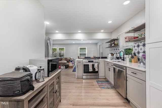 2522 N Roxboro St, Durham, NC 27704 - kitchen featuring stainless steel appliances, a sink, open shelves, light wood-style flooring, and recessed lighting