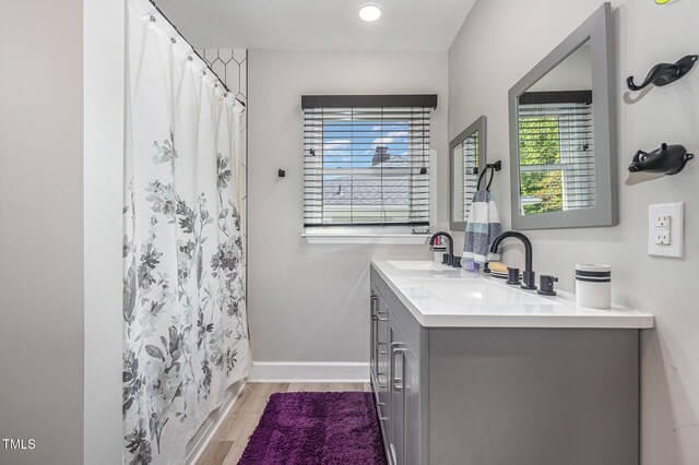2522 N Roxboro St, Durham, NC 27704 - bathroom with wood finished floors, double vanity, baseboards, and curtained shower