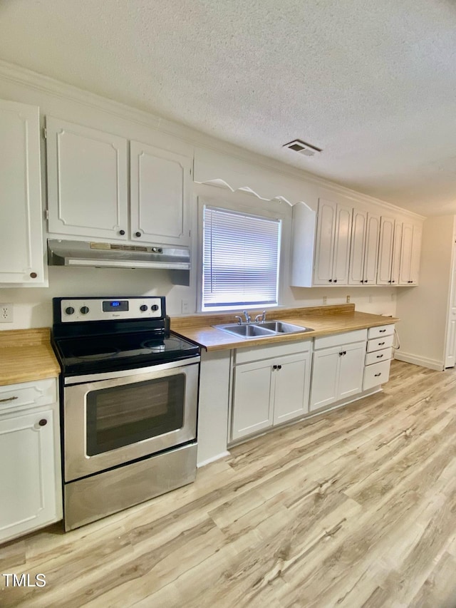 kitchen with under cabinet range hood, light wood-style floors, visible vents, and stainless steel electric range