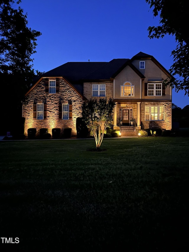 view of front of house featuring stone siding and a front lawn