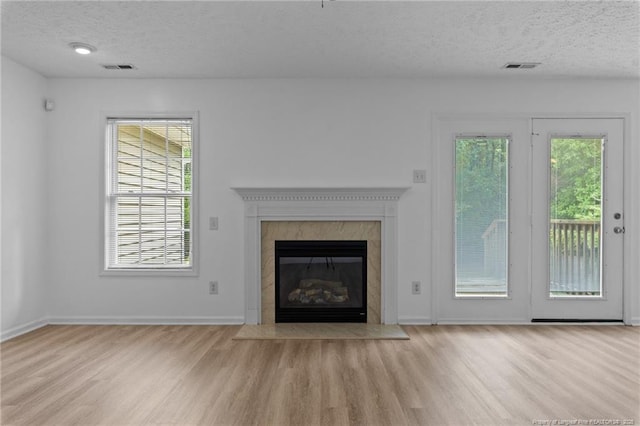 705 Fairfield Cir, Raeford, NC 28376 - unfurnished living room with a textured ceiling, wood finished floors, a high end fireplace, and baseboards