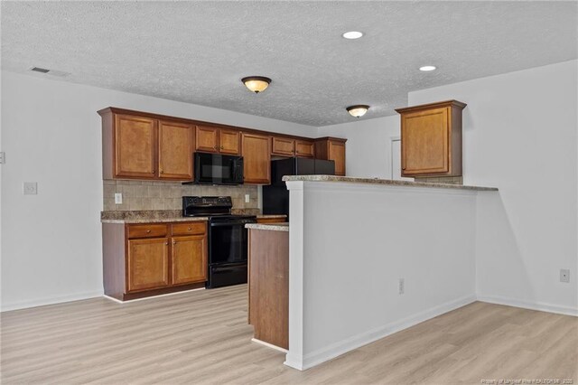 705 Fairfield Cir, Raeford, NC 28376 - kitchen with black appliances, light wood finished floors, brown cabinetry, a textured ceiling, and recessed lighting