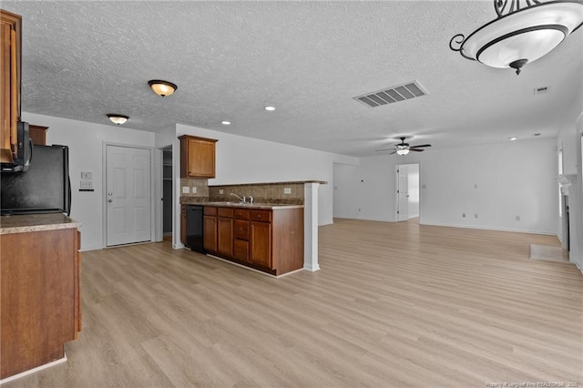 705 Fairfield Cir, Raeford, NC 28376 - kitchen featuring black appliances, brown cabinetry, light wood-style floors, a sink, and baseboards