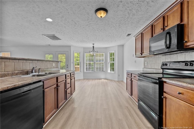 705 Fairfield Cir, Raeford, NC 28376 - kitchen featuring black appliances, a sink, light wood-type flooring, brown cabinets, and decorative backsplash