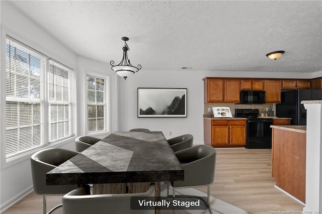 705 Fairfield Cir, Raeford, NC 28376 - dining space with light wood-type flooring, a textured ceiling, and baseboards