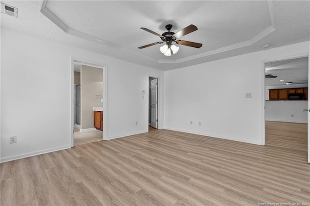 705 Fairfield Cir, Raeford, NC 28376 - empty room featuring a raised ceiling, light wood-type flooring, a ceiling fan, baseboards, and a textured ceiling