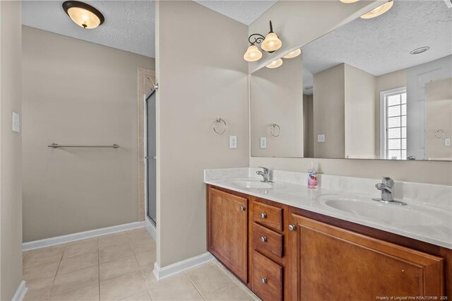705 Fairfield Cir, Raeford, NC 28376 - full bath featuring a textured ceiling, baseboards, a shower with door, and double vanity