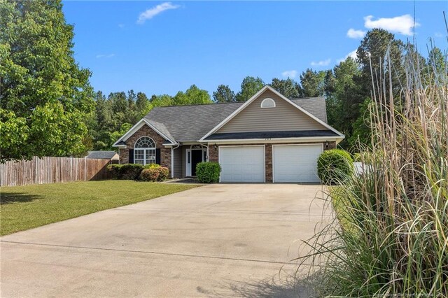 705 Fairfield Cir, Raeford, NC 28376 - view of front facade featuring an attached garage, concrete driveway, brick siding, and roof with shingles