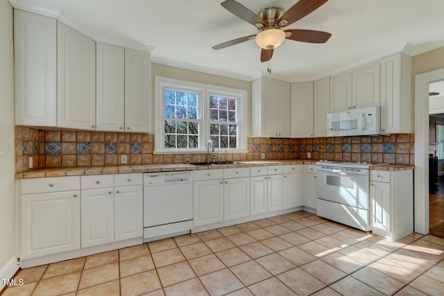 kitchen featuring tasteful backsplash, tile countertops, a sink, and white appliances