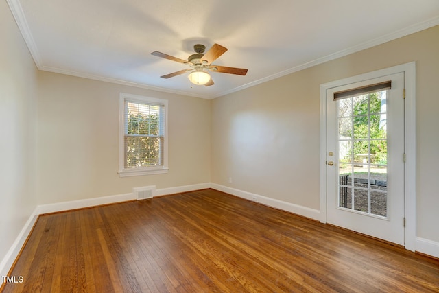 unfurnished room featuring baseboards, ornamental molding, a ceiling fan, visible vents, and wood-type flooring
