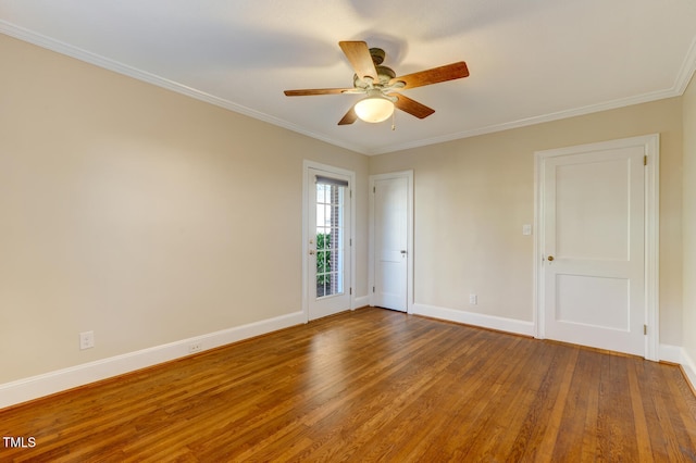 spare room featuring wood finished floors, ceiling fan, baseboards, and ornamental molding