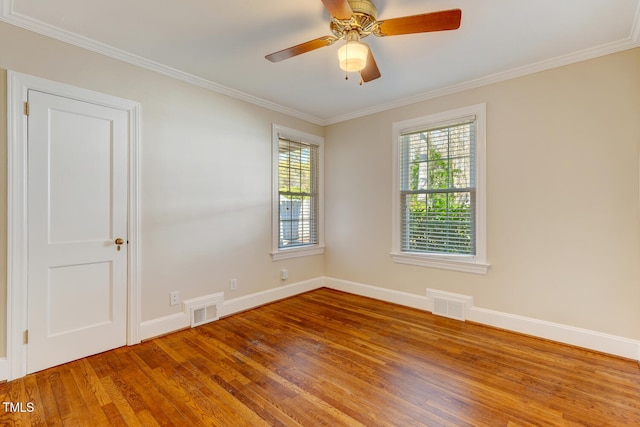 empty room featuring visible vents, baseboards, and wood finished floors