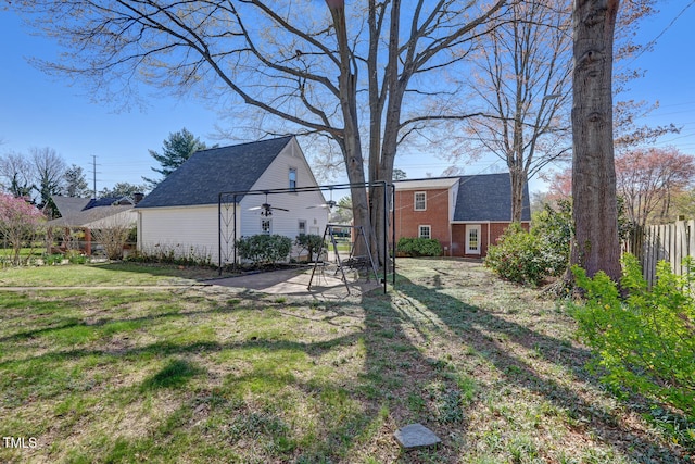 view of yard featuring a patio area, fence, and an outbuilding