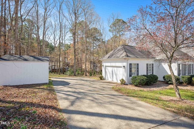 2420 Mollynick Ln, Wake Forest, NC 27587 - view of side of home featuring driveway, an attached garage, an outdoor structure, and a shingled roof