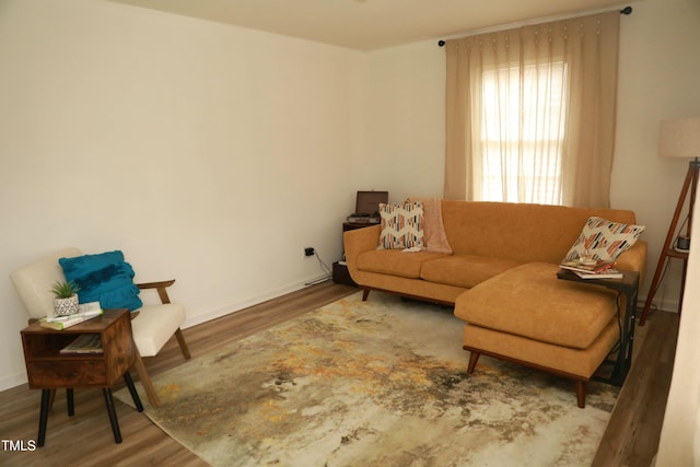 living area featuring baseboards and wood finished floors
