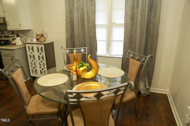 dining space featuring baseboards and dark wood finished floors