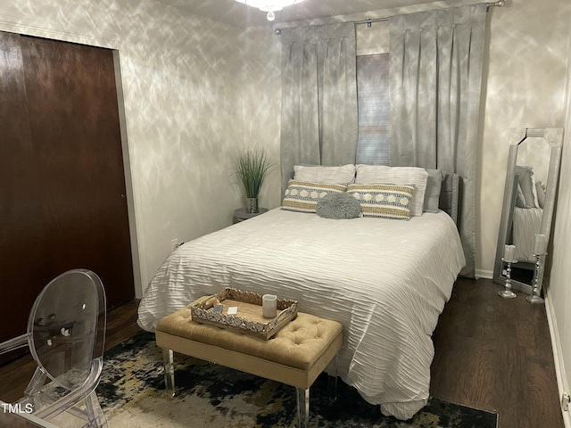 bedroom with baseboards and wood finished floors