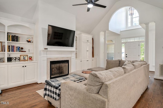 100 Bradborne Cir, Clayton, NC 27520 - living area featuring ceiling fan, high vaulted ceiling, a tiled fireplace, decorative columns, and dark wood-style floors
