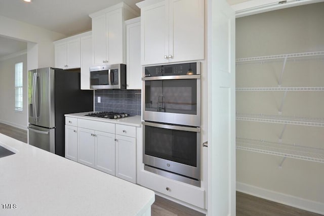 1020 Kentlands Dr, Durham, NC 27713 - kitchen featuring decorative backsplash, appliances with stainless steel finishes, dark wood-style floors, and light countertops