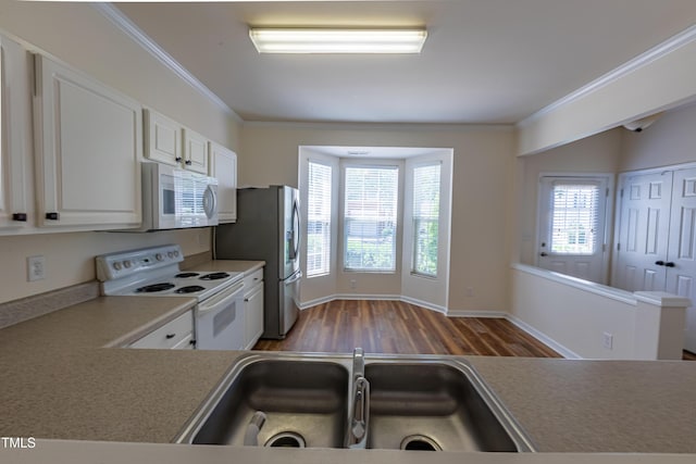 5209 Echo Ridge Rd, Raleigh, NC 27612 - kitchen featuring white appliances, a sink, wood finished floors, ornamental molding, and white cabinets