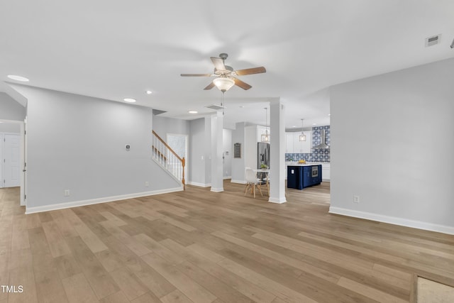 unfurnished living room with a ceiling fan, recessed lighting, light wood-style flooring, and stairway