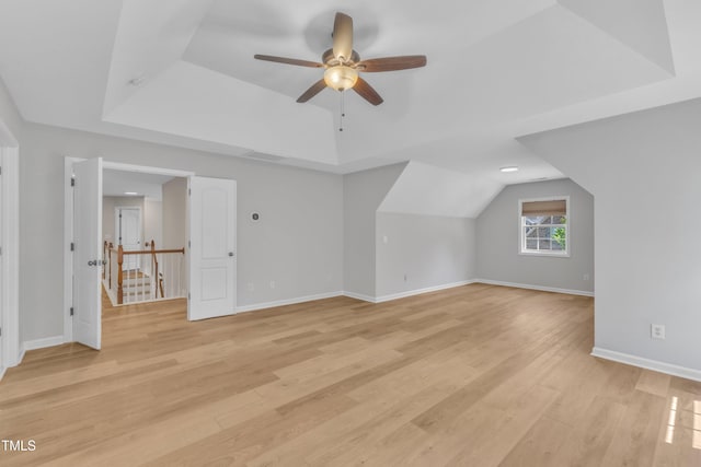 additional living space featuring ceiling fan, visible vents, vaulted ceiling, light wood-type flooring, and baseboards