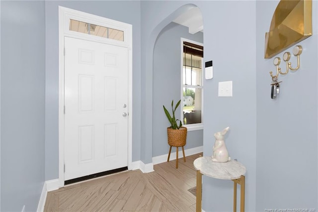 entrance foyer featuring arched walkways and baseboards