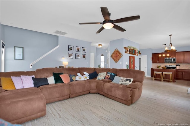 living area with ceiling fan and light wood-style floors
