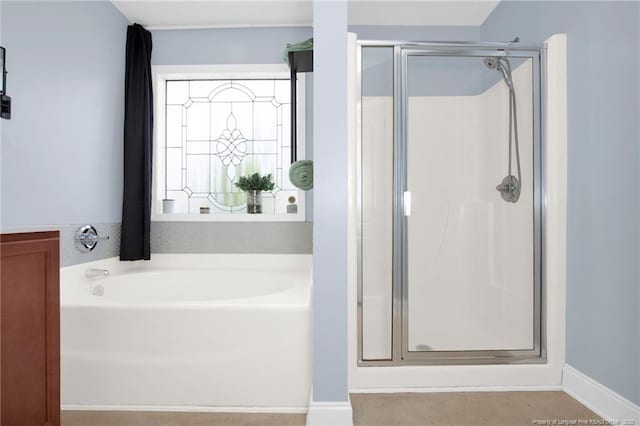 bathroom featuring a shower stall and a garden tub