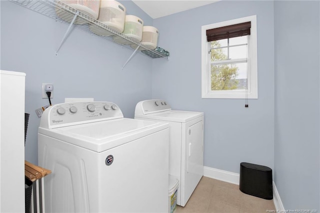 clothes washing area featuring washer and dryer, baseboards, and light tile patterned floors