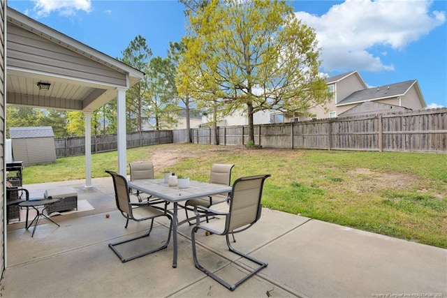 view of patio featuring a storage unit, outdoor dining area, and an outdoor structure