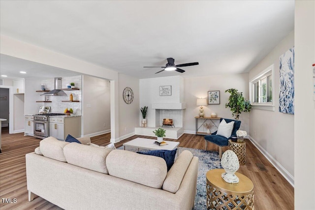 106 Circle Dr, Mebane, NC 27302 - living area featuring wood finished floors, ceiling fan, a fireplace, baseboards, and visible vents