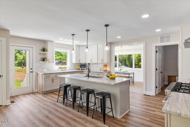 106 Circle Dr, Mebane, NC 27302 - kitchen featuring light wood-style flooring, a sink, tasteful backsplash, visible vents, and open shelves
