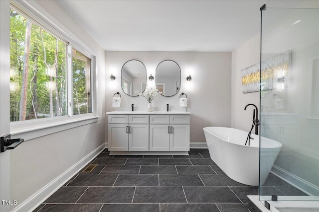 106 Circle Dr, Mebane, NC 27302 - bathroom featuring a freestanding tub, baseboards, and double vanity
