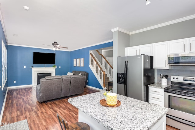 5413 Botany Bay Dr, Raleigh, NC 27616 - kitchen with crown molding, a ceiling fan, white cabinets, dark wood finished floors, and appliances with stainless steel finishes