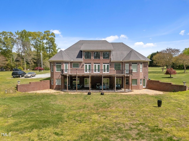 back of property with brick siding, a yard, a patio, and a deck