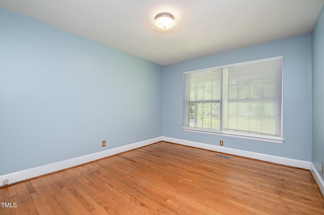 empty room with baseboards and wood finished floors