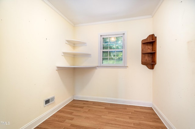 spare room with light wood-style floors, crown molding, and baseboards