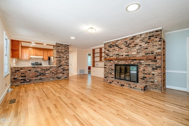 unfurnished living room featuring light wood finished floors, baseboards, crown molding, a fireplace, and a textured ceiling