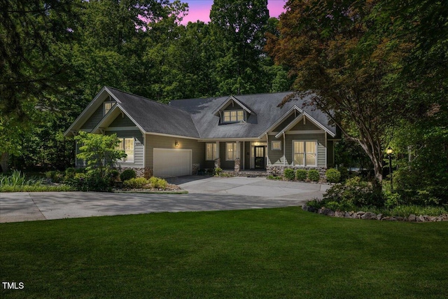 craftsman house featuring a lawn, a garage, driveway, and stone siding