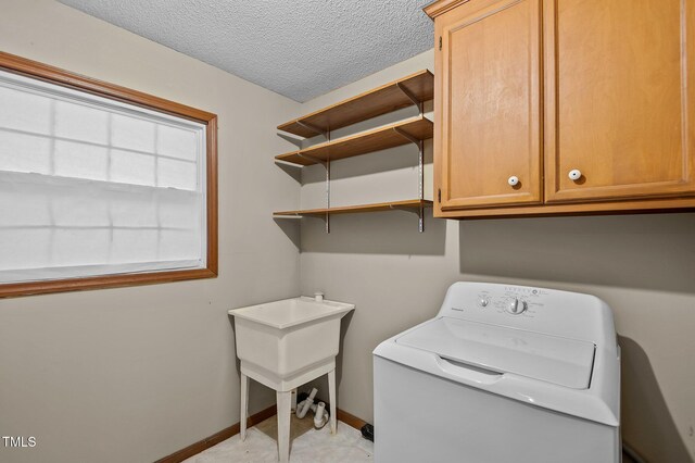 3309 Teal Dr SW, Wilson, NC 27893 - washroom featuring a textured ceiling, baseboards, cabinet space, and washer / dryer