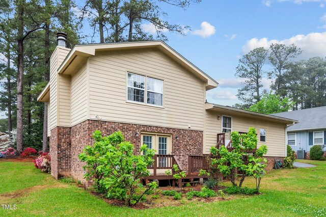3309 Teal Dr SW, Wilson, NC 27893 - rear view of house featuring a yard, brick siding, a deck, and a chimney