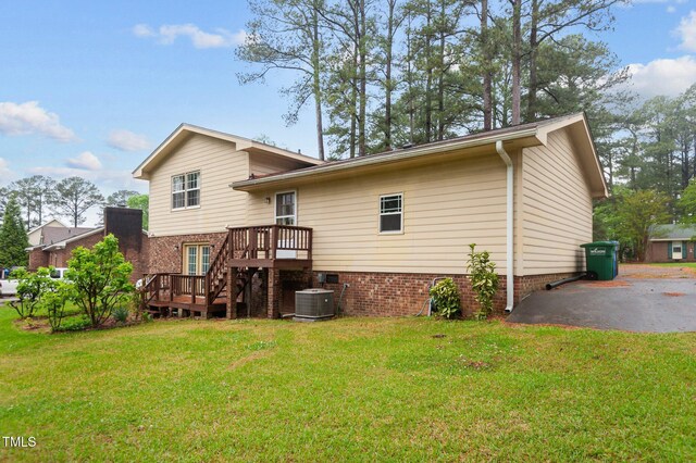 3309 Teal Dr SW, Wilson, NC 27893 - rear view of house with central air condition unit, a wooden deck, and a lawn