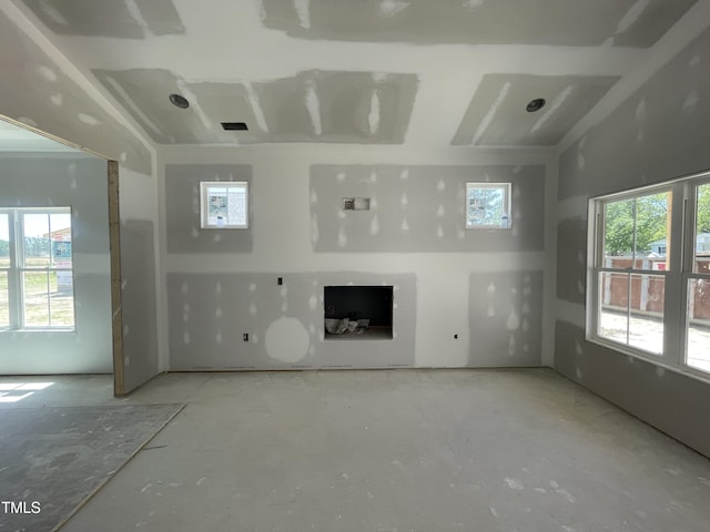 unfurnished living room with plenty of natural light and concrete flooring
