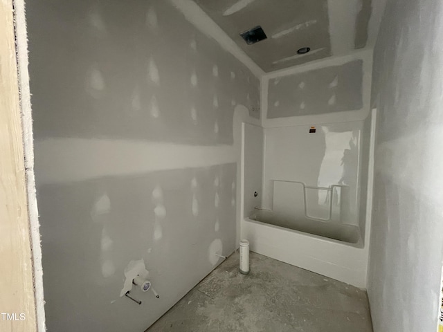 full bath with a bathtub and unfinished concrete flooring