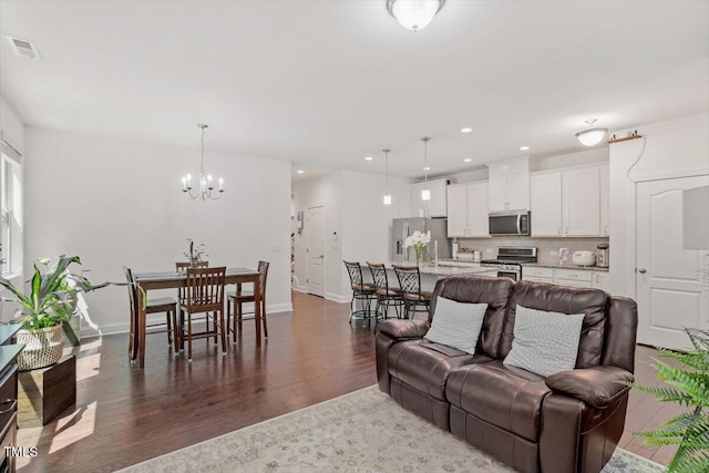 1041 Cotulla Dr, Morrisville, NC 27560 - living room with a notable chandelier, dark wood finished floors, baseboards, and visible vents